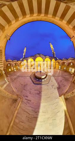 Il cortile della Moschea UC Serefeli di Edirne, Turchia, è stato trasformato in un'incantevole oasi. Illuminato da un delicato bagliore dorato, intri Foto Stock