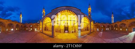 Il cortile della Moschea UC Serefeli a Edirne, in Turchia, si trasforma in un'incantevole oasi. Immersa in una luce soffusa e dorata, architettura intricata e serena Foto Stock