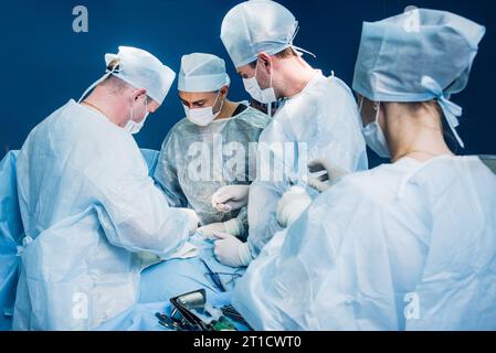 Un team di chirurghi esegue un'operazione complessa per rimuovere una cisti pancreatica utilizzando strumenti medici Foto Stock