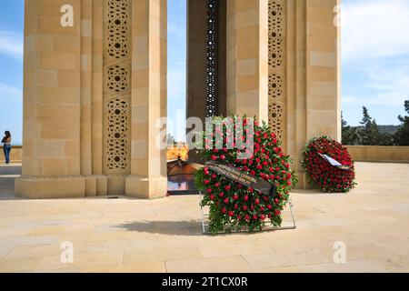 Fiori commemorativi posti alla base dell'imponente e iconico monumento Shahidlar. Al cimitero militare e memoriale di Highland Park a Baku, Azerbaigian. Foto Stock