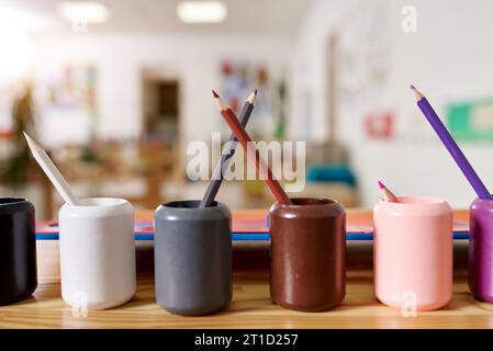 Classe leggera all'asilo di Montessori. I portamatite Montessori colorati sono in primo piano. nessuno. Foto Stock