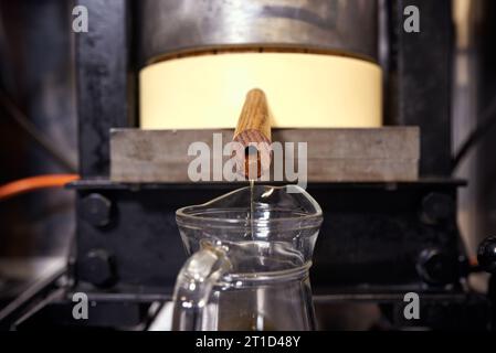 Produzione locale di piccoli oli di semi. Processo di estrazione dell'olio extra vergine di lino fresco. Foto Stock