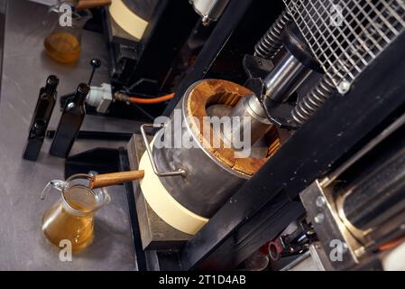 Produzione locale di piccoli oli di semi. Processo di estrazione dell'olio extra vergine di lino fresco. Foto Stock