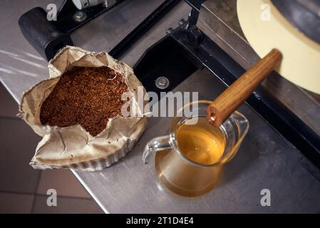 Produzione locale di piccoli oli di semi. Processo di estrazione dell'olio extra vergine di lino fresco. Foto Stock