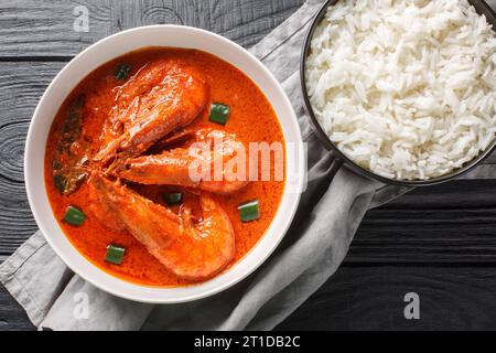 Curry Chingri malai noto anche come curry malai di gamberi fatto con tigre e gamberi reali e latte di cocco e aromatizzato con spezie primo piano sulla t di legno Foto Stock