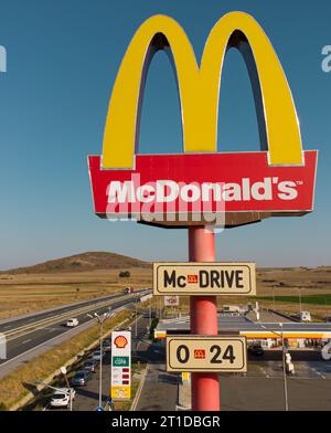 Drazhevo - 1° novembre, cartello McDonald's McDrive presso la stazione di benzina Shell su un'autostrada con vista aerea serale il 1° novembre Drazhevo Bulgaria Foto Stock