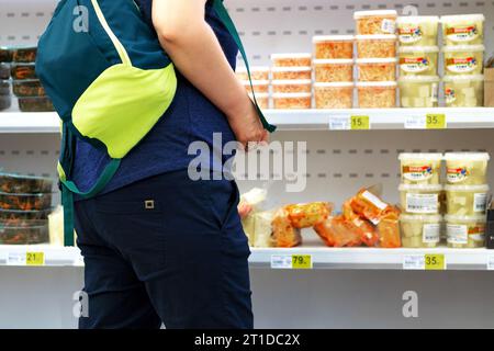 acquirente presso il negozio di alimentari. La ragazza del centro commerciale. Il cliente sceglie, considera i prodotti.la casalinga acquista beni. concept buyer, shopper, shop Foto Stock