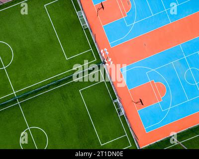vista aerea di un campo da calcio verde e di un colorato campo da pallacanestro, che offre uno scorcio di due diverse strutture sportive affiancate. Il controtra Foto Stock