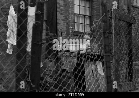 Fratello e sorella giocano nel cortile della loro casa vittoriana a schiera durante la slum clearance di St Ann's, Nottingham, Inghilterra. 1969-1972 Foto Stock