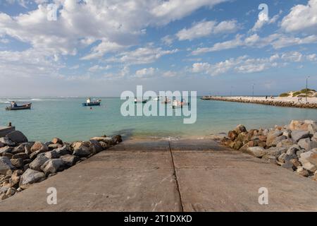 Una scenografia pittoresca si svolge con le colorate barche da pesca ormeggiate serenamente al sole radioso di un porto tranquillo Foto Stock