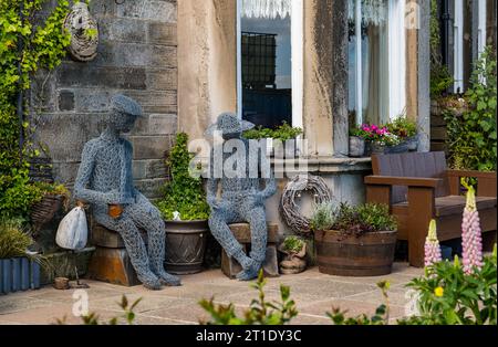 Stravaganti figure scultoree in rete metallica sedute in un giardino frontale, Portobello, Edimburgo, Scozia, Regno Unito Foto Stock