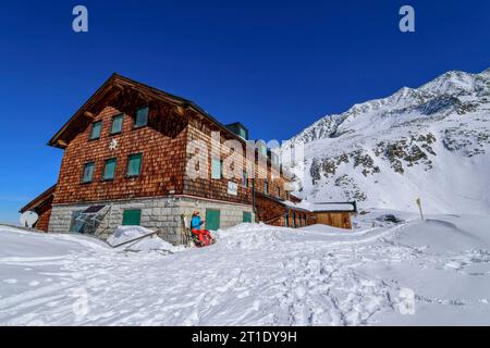 Donna in tour sciistico seduta al Rifugio Zittau, Parco Nazionale alti Tauri, Alpi Zillertal, Tirolo, Austria Foto Stock