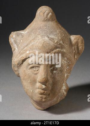 Testa con casco frigio, periodo tolemaico-periodo romano (332 a.C.-337 d.C.). Foto Stock