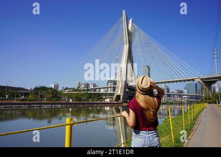 Visita a San Paolo, Brasile. Vista posteriore di una viaggiatrice che guarda il ponte Estaiada a San Paolo, Brasile. Foto Stock