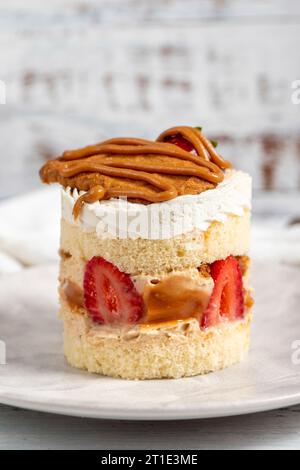 Torta di fragole e caramello. Torta fresca con caramello e fragole su un piatto. Primo piano Foto Stock