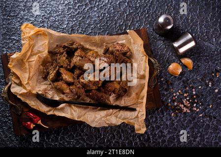 Fegato di pollo fritto con cipolle ed erbe aromatiche. Foto Stock