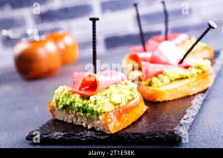 Panini integrali con prosciutto e avocado. Mangiare pulito, colazione sana. Vista dall'alto, base piatta Foto Stock