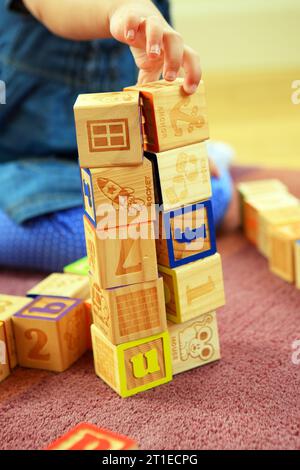 Bambina di due anni che gioca e impara con i mattoni Foto Stock