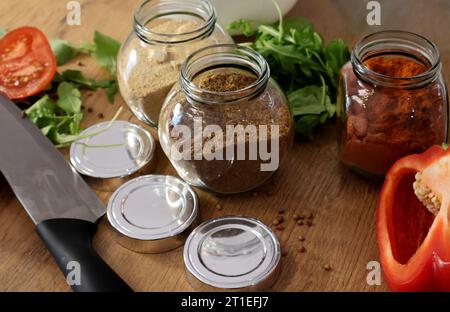 paprika affumicata, aglio secco e coriandolo. Speziato nei vasetti sul tavolo di legno.C. Foto Stock