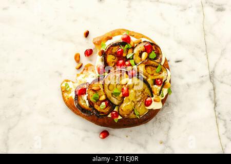 Mini focaccia con melanzane, yogurt allo zafferano e semi di melograno Foto Stock