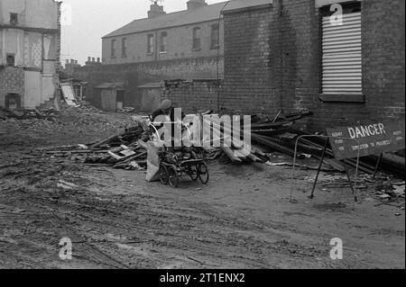 Un anziano che raccoglie legna da ardere in una carrozza da un sito di demolizione su Guys Terrace durante lo slum di Victorian St Ann's, Nottingham, 1969-1972 Foto Stock