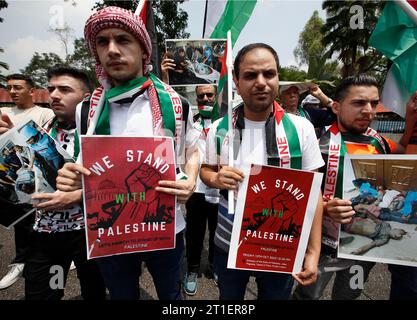 Kuala Lumpur, Malesia. 13 ottobre 2023. I manifestanti tengono cartelli durante la manifestazione di solidarietà con la Palestina presso l'edificio dell'ambasciata palestinese a Kuala Lumpur. La solidarietà consiste nel chiedere protezione internazionale al popolo palestinese attaccato a Gaza. Credito: SOPA Images Limited/Alamy Live News Foto Stock