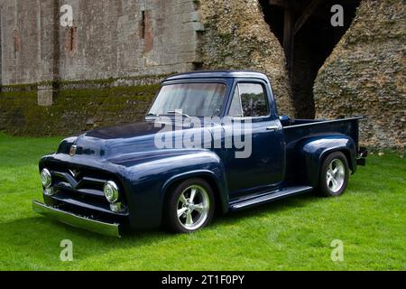 Camion Ford americano degli anni '1950, parcheggiato su prati vicino a un'antica cinta muraria del castello Foto Stock