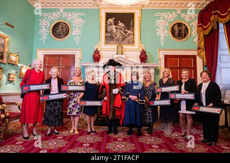 (Da sinistra a destra) Hilary Pearson, Anthea Gaukroger, Michelle McAtee, Christine Spencer, Lord Mayor Nichols Lyons, Chief commoner Ann Holmes, Linda Treacy, Sarah Danes, Janet Stevens e Beryl Gayler, alle prime donne commercianti di City viene data la libertà della città di Londra alla Mansion House in riconoscimento dei loro risultati rivoluzionari nel settore dei servizi finanziari della capitale. Data immagine: Venerdì 13 ottobre 2023. Foto Stock