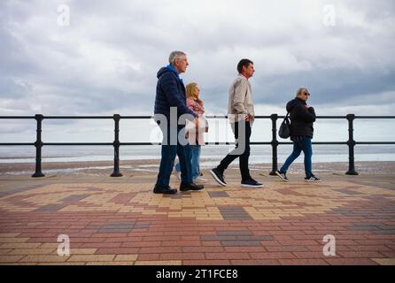 Un gruppo di due uomini e due donne che camminano sul ballo di Cleethorpes Foto Stock