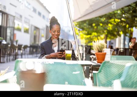 Ritratto di una donna d'affari matura seduta in un caffè all'aperto Foto Stock