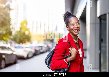 Donna matura sicura di sé che cammina in città Foto Stock