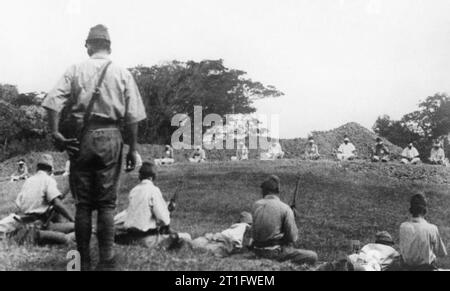 Atrocità perpetrate dalle forze giapponesi durante la seconda guerra mondiale la guerra ufficio, UFFICIO CENTRALE DI INFORMAZIONE E AMERICAN SECONDA GUERRA MONDIALE raccolta ufficiale. Questo set di quattro immagini di atrocità è stata trovata tra i record giapponese quando le truppe britanniche è entrato a Singapore. Mostra immagine:- Questa mostra i soldati giapponesi caricando i fucili e tenetevi pronti a sparare loro prigionieri Sikh, che sono seduti, con gli occhi bendati in una ruvida semi-cerchio, 20 metri di distanza. Foto Stock