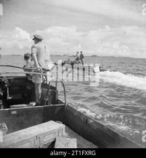 Il Britannico la rioccupazione del Singapore DUKWs di 56 Acqua unità di trasporto, Royal Army Service Corps (RASC), caricato con munizioni giapponese raccolti da dump in Singapore, fanno la loro strada verso l'attesa landing craft sul quale le munizioni saranno trasferiti prima di essere scaricato in mare. Foto Stock