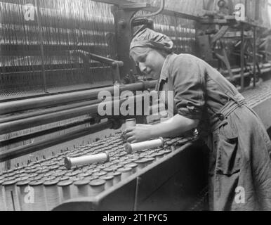 Industria durante la Prima Guerra Mondiale- Leicestershire un lavoratore di sesso femminile che sostituisce bobine vuote di filo in una tenda di pizzo macchina in una fabbrica di Nottingham nel settembre 1918. Foto Stock