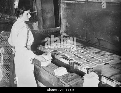 Donne lavoro guerra 1914-1918 una donna lavoratrice in un Lancashire biscottificio esercito di cottura biscotti in un forno rotante. Foto Stock