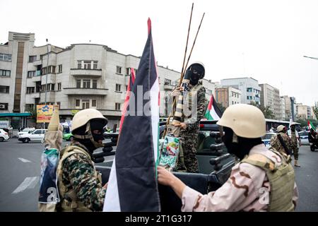 Teheran, Iran. 13 ottobre 2023. I membri della forza paramilitare iraniana Basij, nello stile dei militanti palestinesi e libanesi, si parlano tra loro durante un raduno pro-palestinese prima della preghiera del venerdì a Teheran, Iran, venerdì 13 ottobre 2023. (Foto di Sobhan Farajvan/Pacific Press) credito: Pacific Press Media Production Corp./Alamy Live News Foto Stock