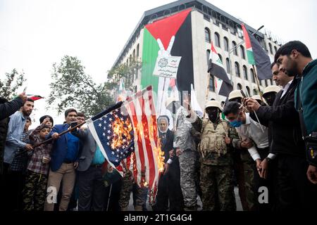Teheran, Iran. 13 ottobre 2023. I fedeli iraniani bruciano una bandiera degli Stati Uniti durante il loro raduno pro-palestinese prima delle preghiere del venerdì. (Foto di Sobhan Farajvan/Pacific Press) credito: Pacific Press Media Production Corp./Alamy Live News Foto Stock