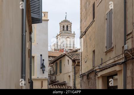 Affacciato su una stretta strada nel cuore dell'antica città di Arles in Provenza, nel sud della Francia. La torre del municipio è sullo sfondo. Foto Stock