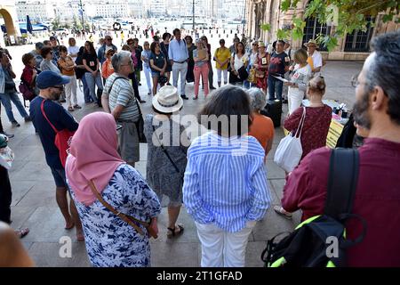 I partecipanti ascoltano un discorso durante la dimostrazione. Circa cinquanta persone si sono riunite a Place Bargemon a Marsiglia per sostenere le donne afghane e chiedere il diritto di asilo immediato per coloro che sono perseguitati e minacciati in Afghanistan. Foto Stock