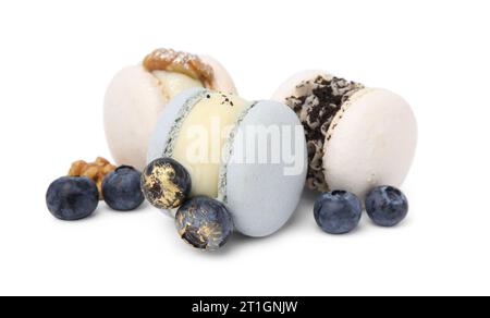 Deliziosi macaron, noci e mirtilli isolati su bianco Foto Stock