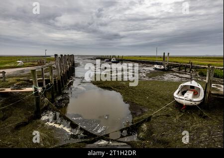 PRODUZIONE - 29 settembre 2023, Schleswig-Holstein, Hallig Langeneß: Le navi sono ormeggiate nel porto di Hallig Oland con la bassa marea. (A dpa-Korr "il cambiamento climatico mette Halligen sotto pressione ancora maggiore") foto: Axel Heimken/dpa Foto Stock