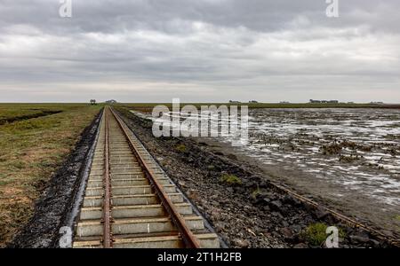 PRODUZIONE - 29 settembre 2023, Schleswig-Holstein, Hallig Langeneß: Una linea ferroviaria per carrelli conduce all'Halligen nel Mare del Nord. (A dpa-Korr "il cambiamento climatico mette Halligen sotto pressione ancora maggiore") foto: Axel Heimken/dpa Foto Stock