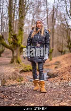 Molto felice giovane ragazza bionda in un servizio fotografico in una splendida foresta Foto Stock