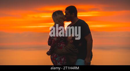 Romanticismo sulla cima di una montagna Una giovane coppia che si baciava accanto al figlio. Stile di vita Avventuroso Un pomeriggio d'estate sulle montagne basche Foto Stock