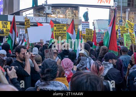 NEW YORK, NEW YORK - 13 OTTOBRE: I manifestanti pro-palestinesi, sostenuti dal capitolo newyorkese dei Socialisti Democratici (DSA), detengono segni e bandiere durante una protesta palestinese a Day of Action a Times Square il 13 ottobre 2023 a New York City. In tutto il paese e in tutto il mondo, la gente sta organizzando manifestazioni e veglie sia per palestinesi che per israeliani a seguito di un attacco a sorpresa di Hamas il 7 ottobre. L'attacco ha portato a un bombardamento di Gaza da parte dell'esercito israeliano e a una possibile invasione terrestre del territorio. Foto Stock