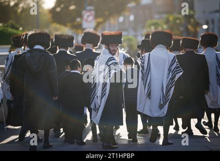 Londra, Regno Unito. 14 ottobre 2023. I membri della comunità ebraica ortodossa si recano alle preghiere mattutine durante lo Shabbat ebraico, a Stamford Hill, a nord di Londra. Migliaia di persone dovrebbero scendere per le strade del centro di Londra in seguito per protestare contro il pianificato assalto israeliano a Gaza. Israele ha dichiarato guerra all'organizzazione terroristica Hamas, dopo che i militanti di Hamas hanno invaso Israele con un brutale attacco ai civili, uccidendo oltre 1000 persone. Crediti fotografici: Ben Cawthra/Sipa USA credito: SIPA USA/Alamy Live News Foto Stock