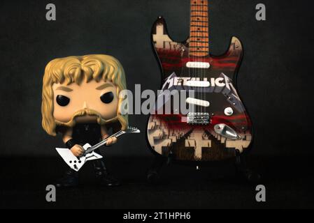 Funko POP in vinile di James hetfield cantante del gruppo heavy metal americano metallica accanto a una chitarra elettrica su sfondo scuro. Illustrazione Foto Stock