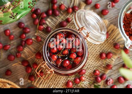 Preparazione di vino medicinale da bacche di biancospino fresche in autunno Foto Stock