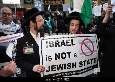 Gli uomini ebrei a sostegno della pace mantengono i segnali mentre i sostenitori palestinesi si riuniscono a Times Square per protestare in risposta alla guerra in corso tra Israele e Hamas a New York il 13 ottobre 2023. (Foto: Gordon Donovan) Foto Stock