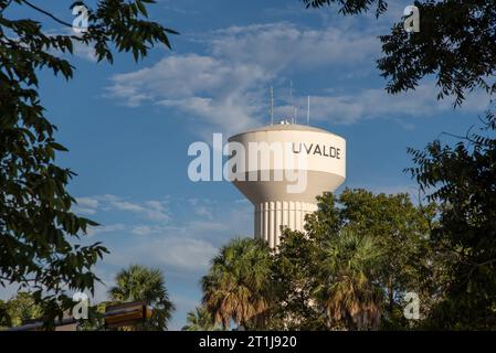 Guarda la torre dell'acqua municipale bianca incorniciata da alberi a Uvalde, Quay County, Texas, Stati Uniti. Foto Stock